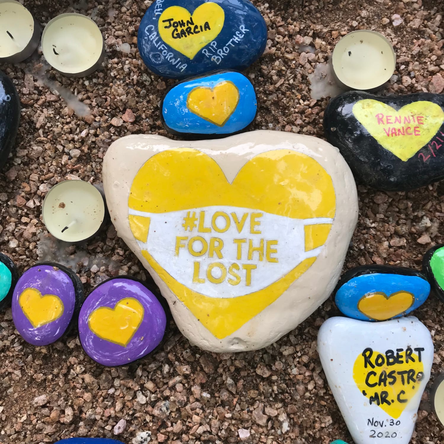 A rock of a heart wearing a mask for COVID at the Parr Park Rock Art Trail