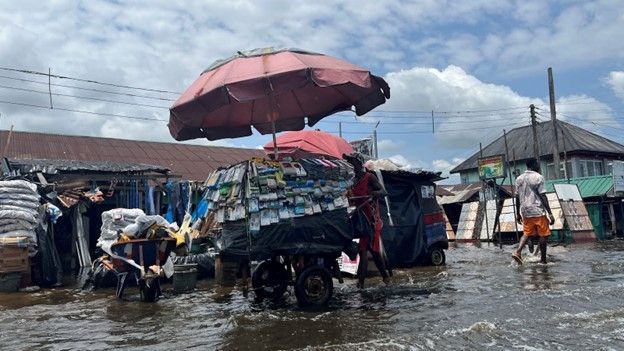 A man pushes a cart across the street as flood water continues to displace people in Yenagoa Nigeria, October 18, 2022. (REUTERS/Tife Owolabi)