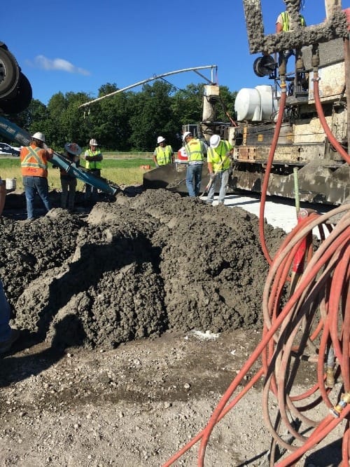 Construction workers use a chute to place concrete. 