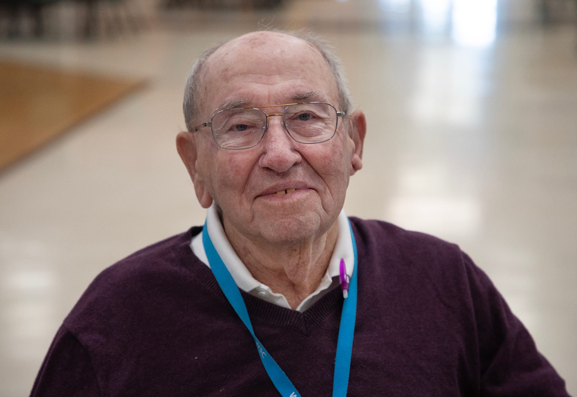 A close-up portrait of an older man, smiling.