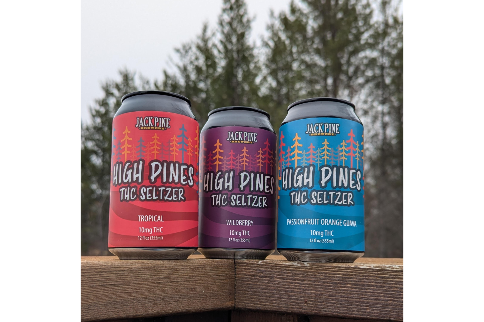 Three cans of THC-infused beverages sit on a railing.