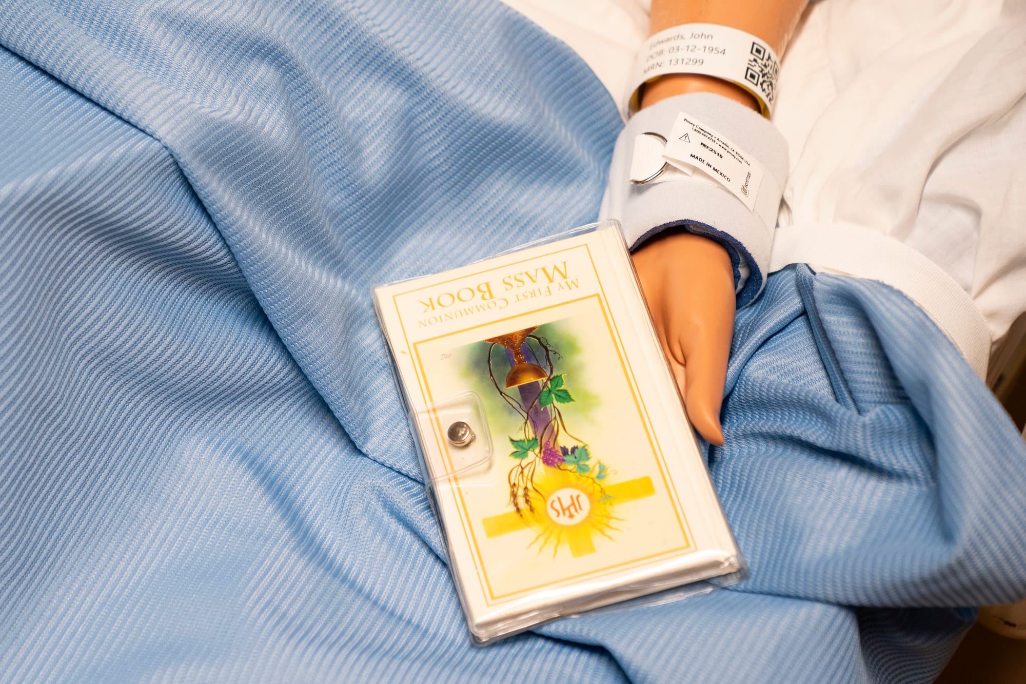 A prayer book is seen in the patient's bed. 