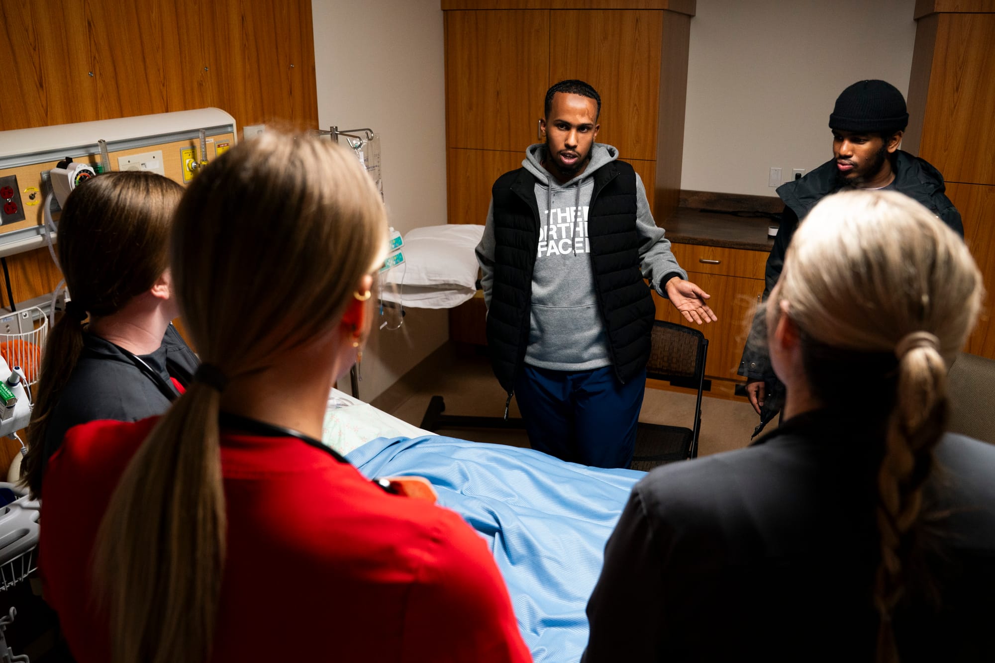 A patient's family ask nursing students questions during a training exercise. 