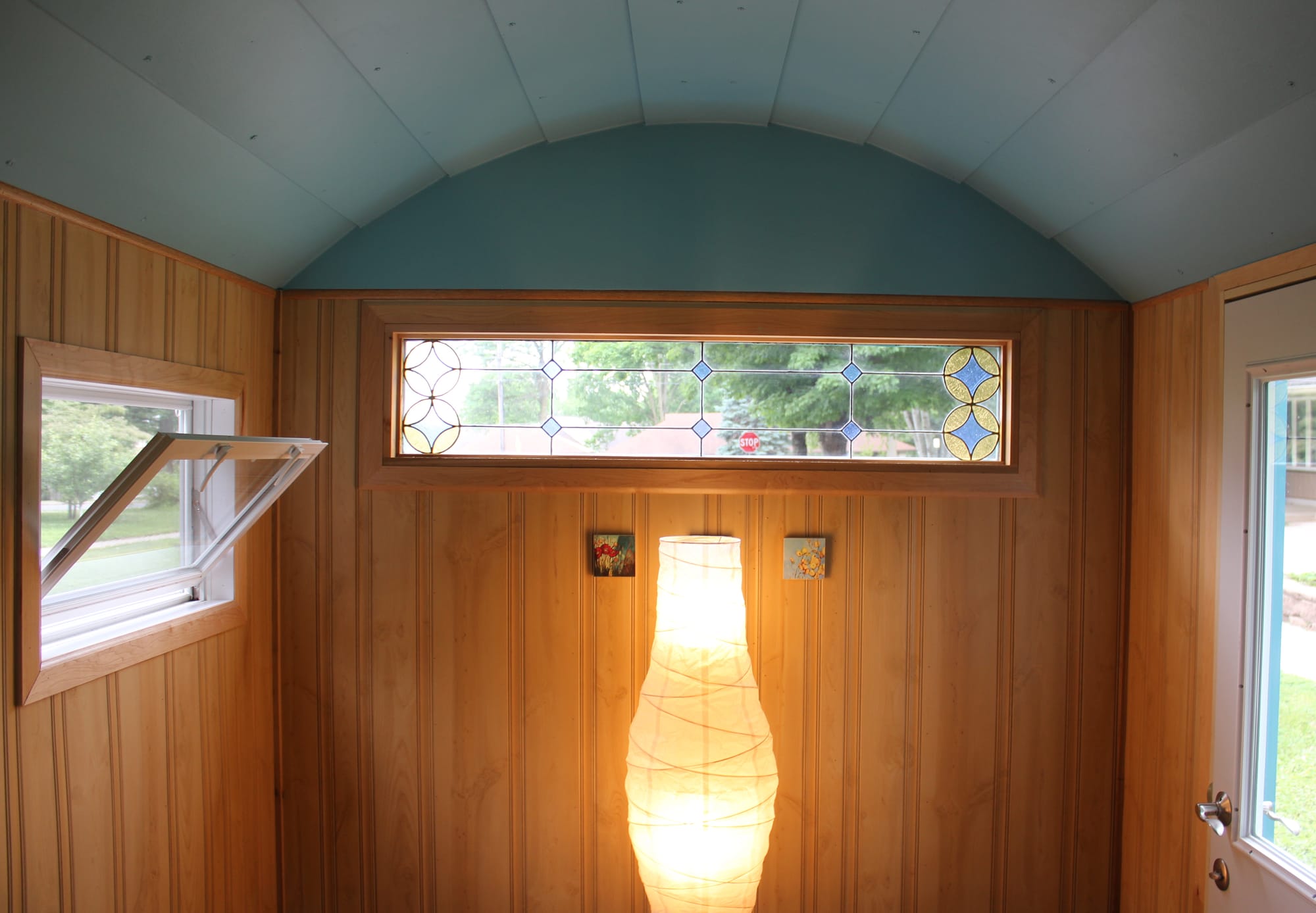 The inside of "The Wandering House" has wood paneling, a stained glass window and cozy lighting. 