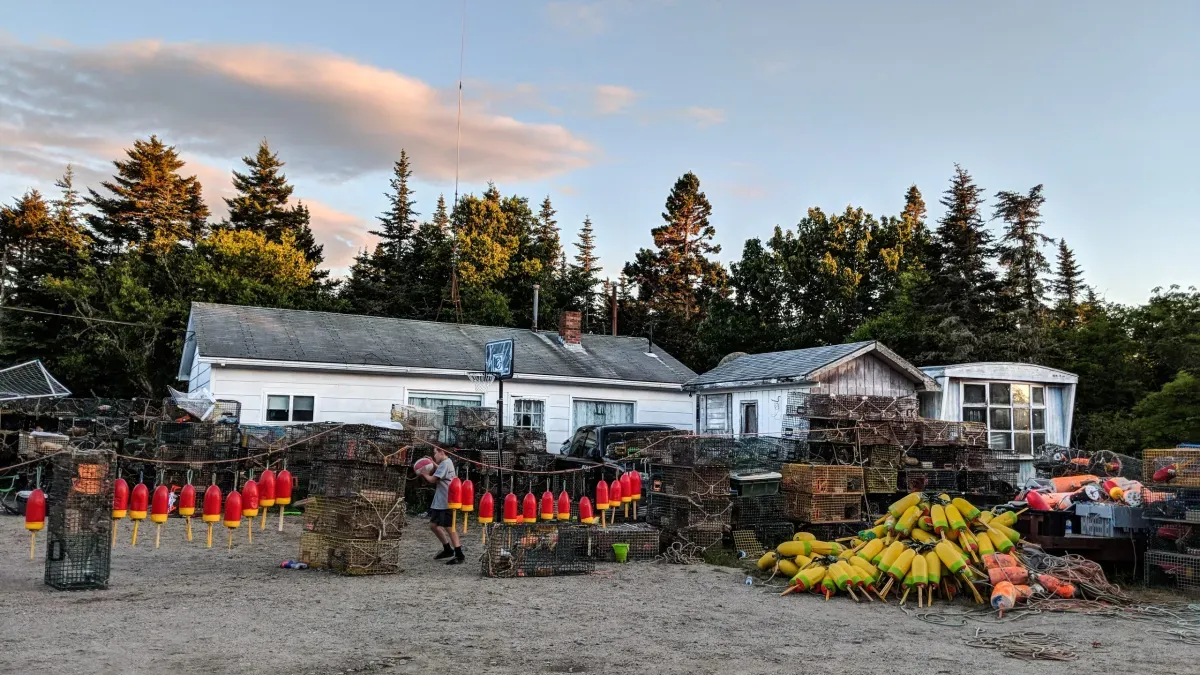A-boy-plays-basketball-among-lobster-traps-in-Jonesport,-Washington-County,-Maine.-(Photo-by-Carolyn-Campbell)