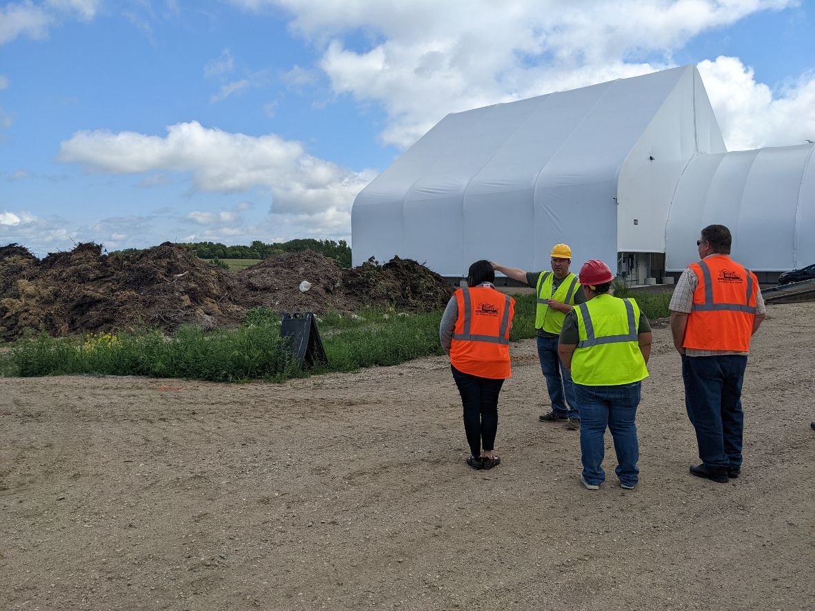 Staff and visitors talk outside the new Glacial Ridge Compost Facility in Hoffman, Minn., on Tuesday, Aug. 16, 2022. (Nora Hertel for Project Optimist)