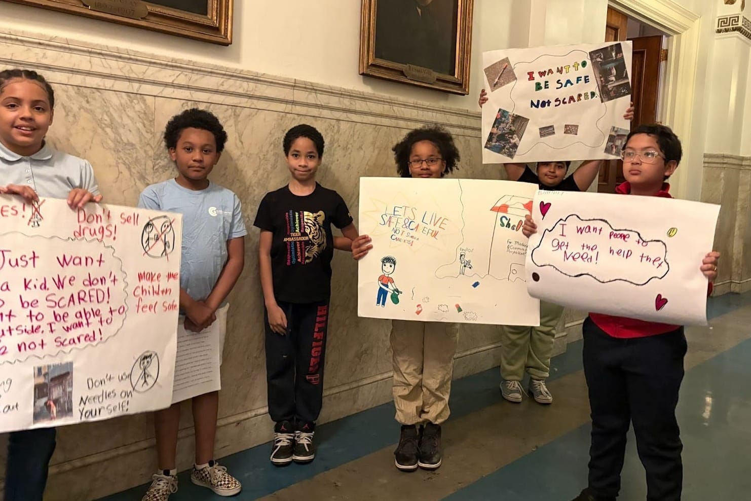 Students hold signs at City Council