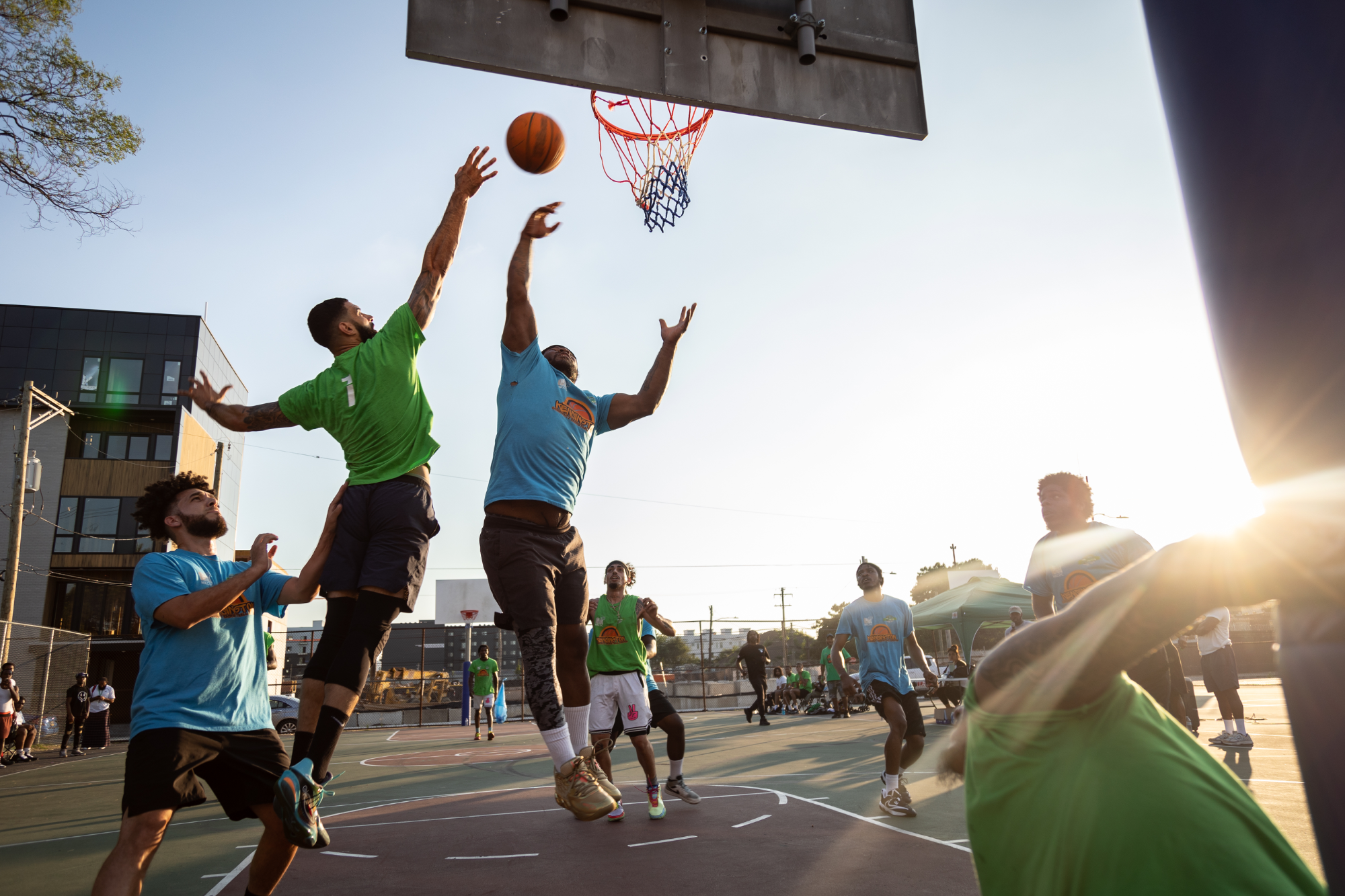 Two players leap toward the basket during Cure Violence basketball game