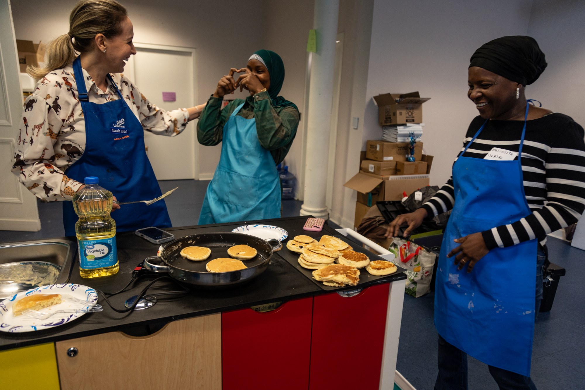 Students prepare pancakes during Edible Alphabet English class at Lillian Marrero Library