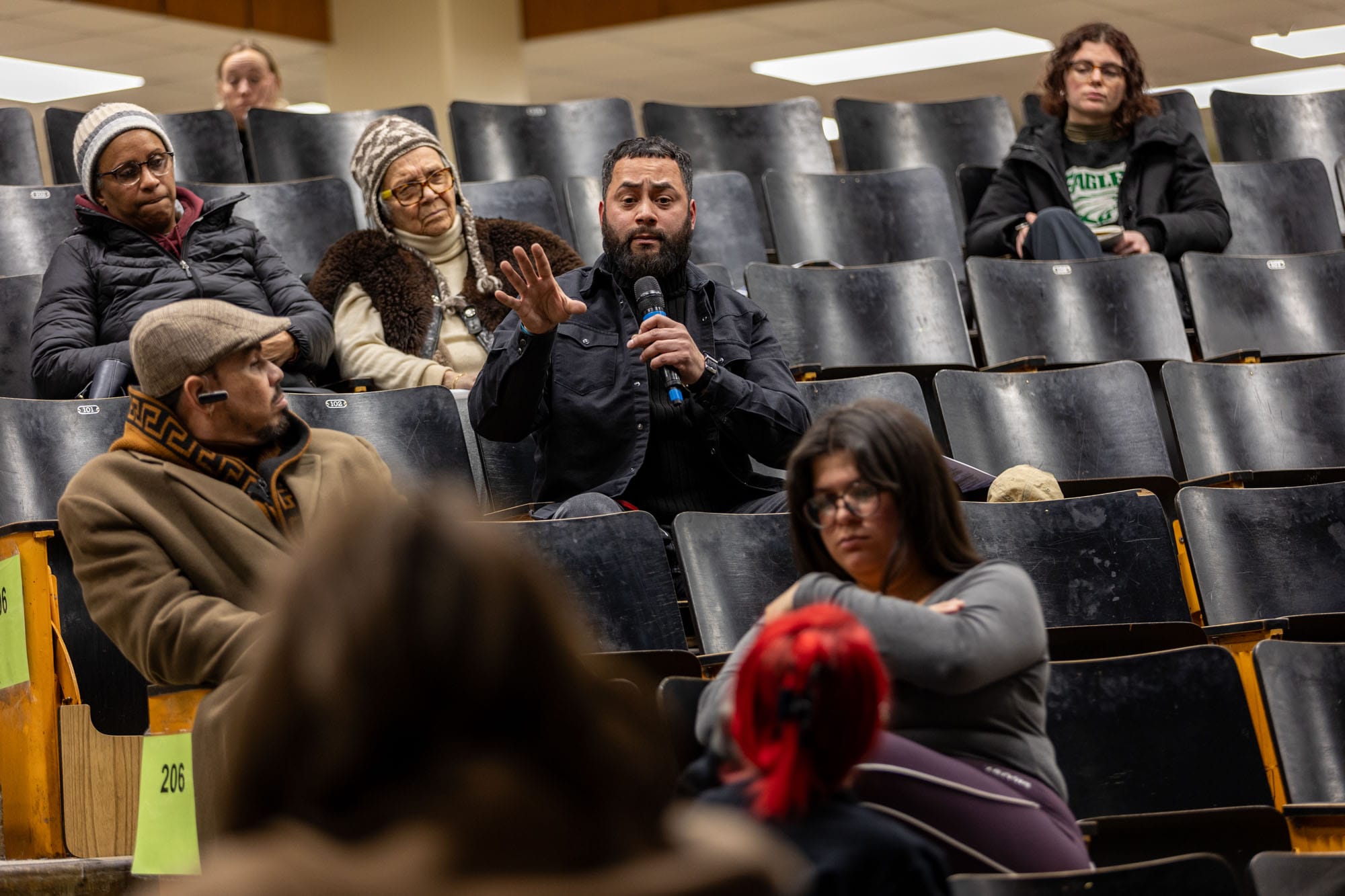 Man speaks into microphone at Lewis Elkin Elementary meeting