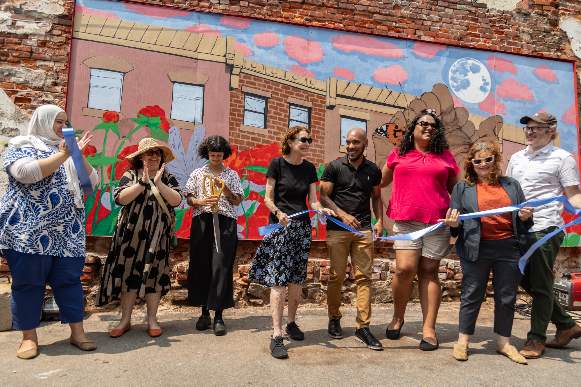 Paula Rivera Calderón cuts the ribbon at the Prevention Point mural dedication at the Love Lot