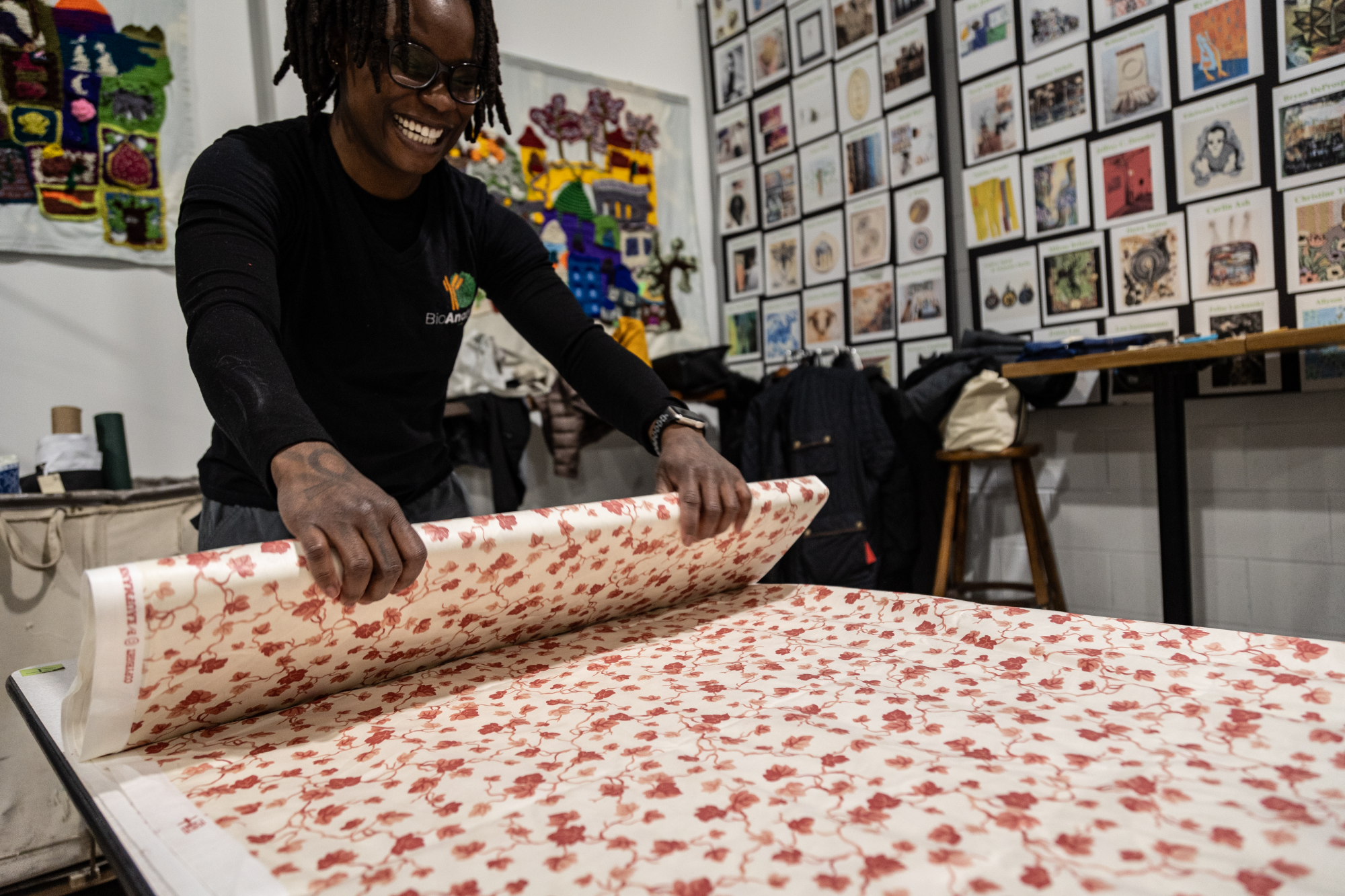 Volunteer unrolls fabric at Save + Sort Resource Exchange