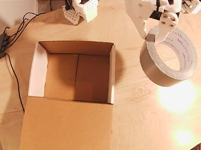 Tape held above the table before transfer to the box