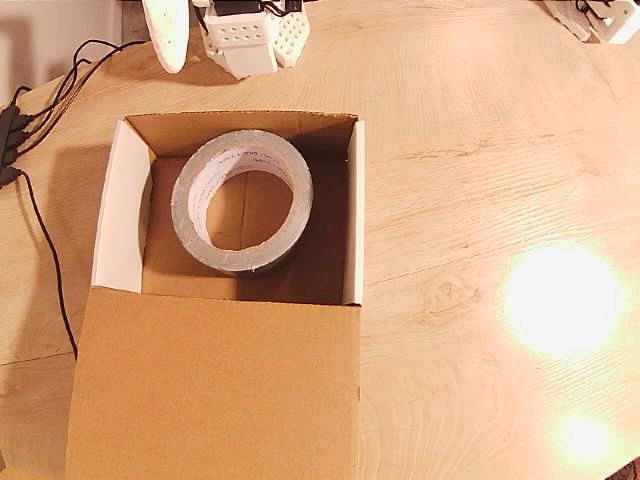 Tape resting inside the box with the gripper withdrawn