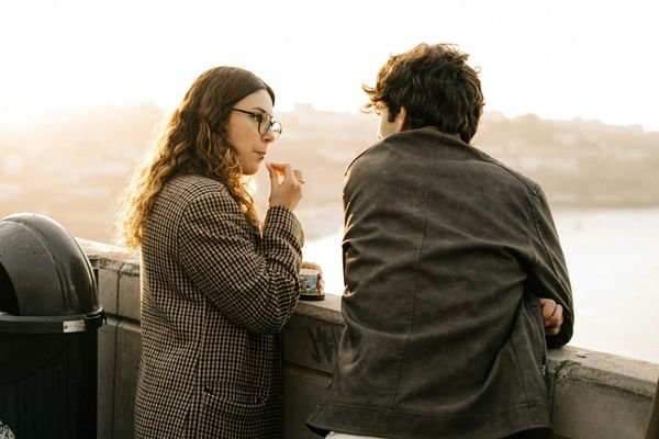 Two adults having a relaxed conversation outdoors by the water