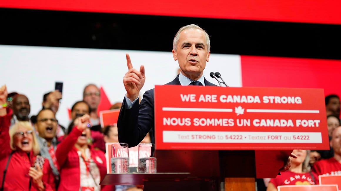 Prime Minister Mark Carney speaking at a podium with the words, "we are canada strong"