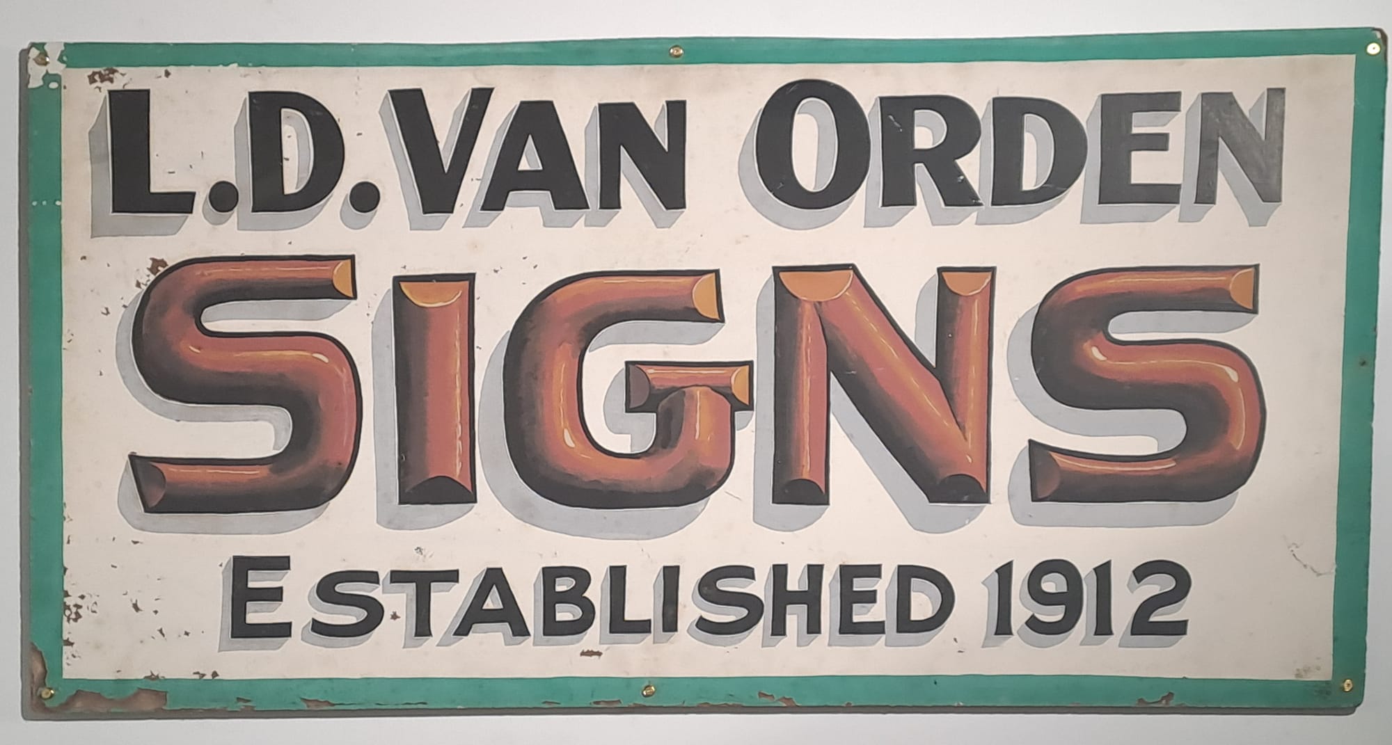 Simple hand-lettered sign that reads "L.D. Van Orden, Signs, Established 1912". The word 'signs' is painted in red with dimensional effects that make the letters appear to be curved.