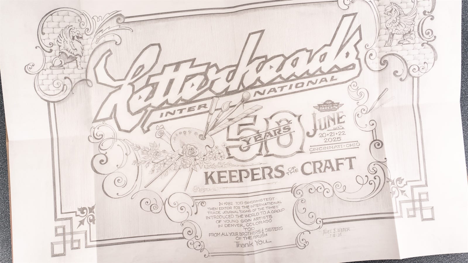 Photo of a poster with an ornamented pencil layout with lettering dominated by "Letterheads International, 50 Years, Keepers of the Craft".
