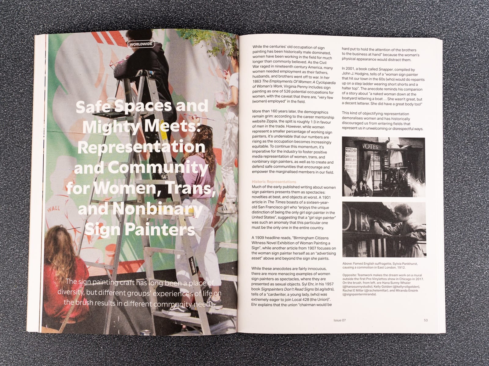 Photo of a magazine opened up to show a spread with text and archival photos of a woman painting a sign on the right side. On the left is a full bleed colourful contemporary image of three women painting a mural sign over which is laid the headline in white text.