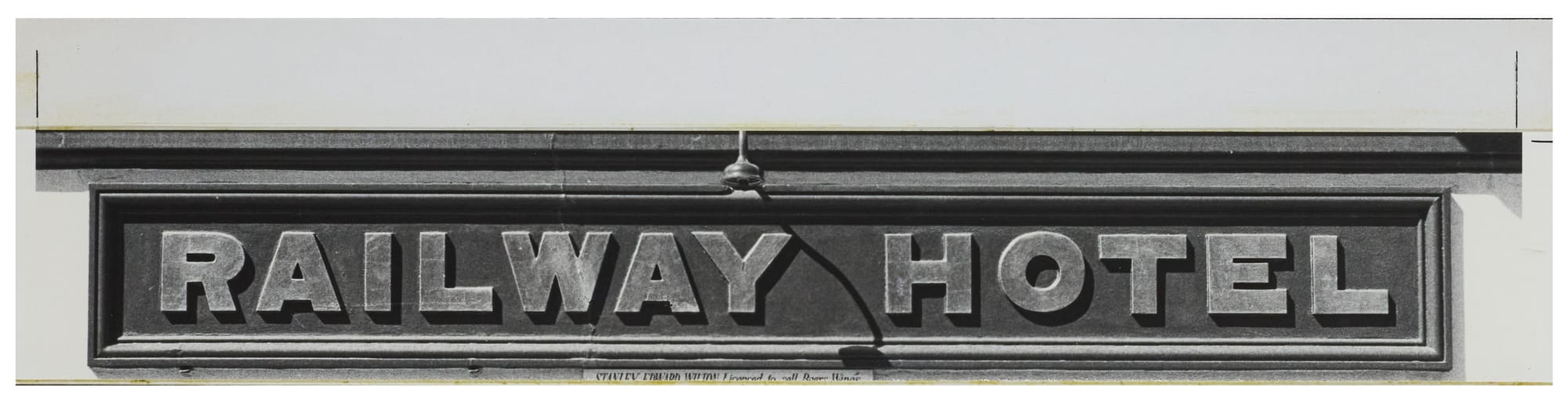 Cropped in photo of lettering that says "Railway Hotel" set tightly within an oblong frame.