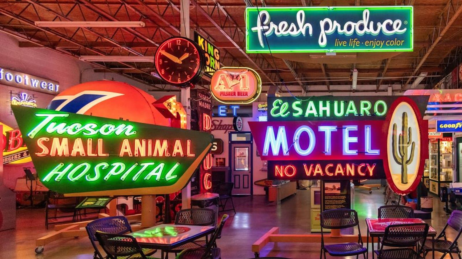 Wide-angle photo of a museum gallery space filled with brightly coloured neon signs.