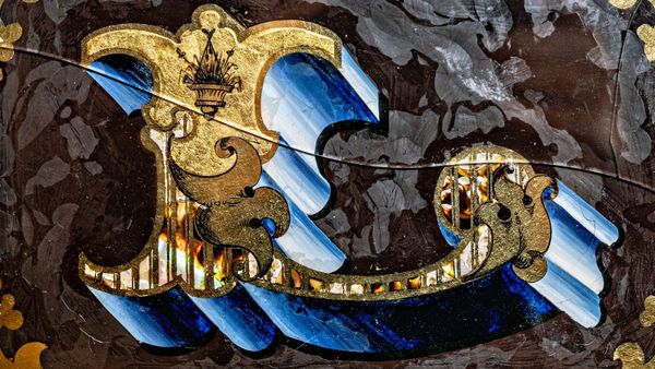 Ornate Tuscan letter L with its face and block shade decorated with a variety of gilded and painted effects..