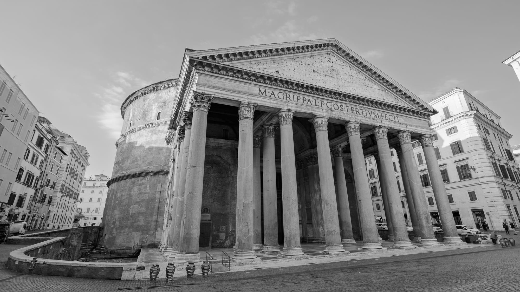 Historic Pantheon in Rome captured in black and white during early morning solitude, showing the ancient temple's imposing columns and dome without tourists.