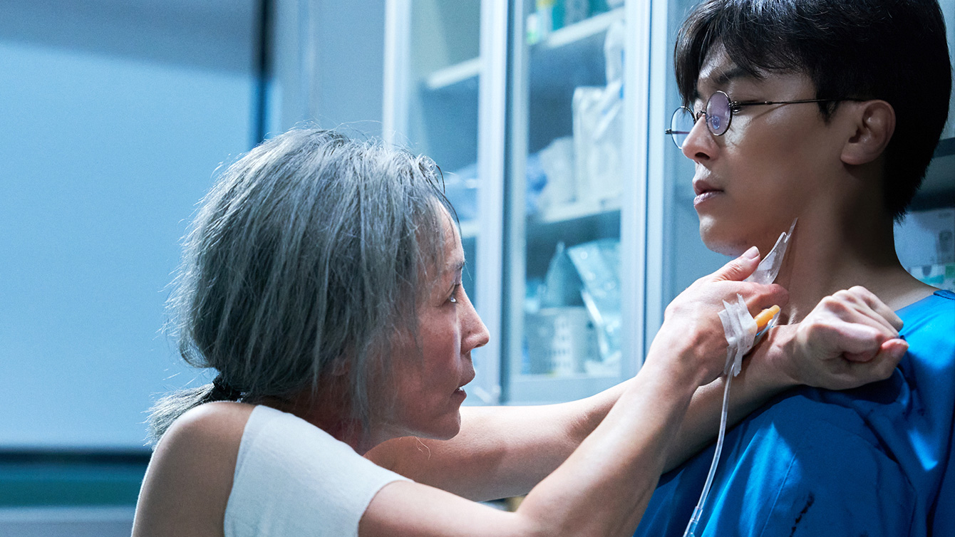 Lee Hye-young holds up a blade to a doctor's neck in The Old Woman with the Knife