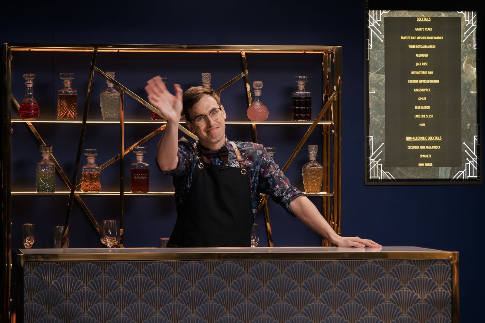 Grant O'Brien waves from behind the bar on the set of Dirty Laundry