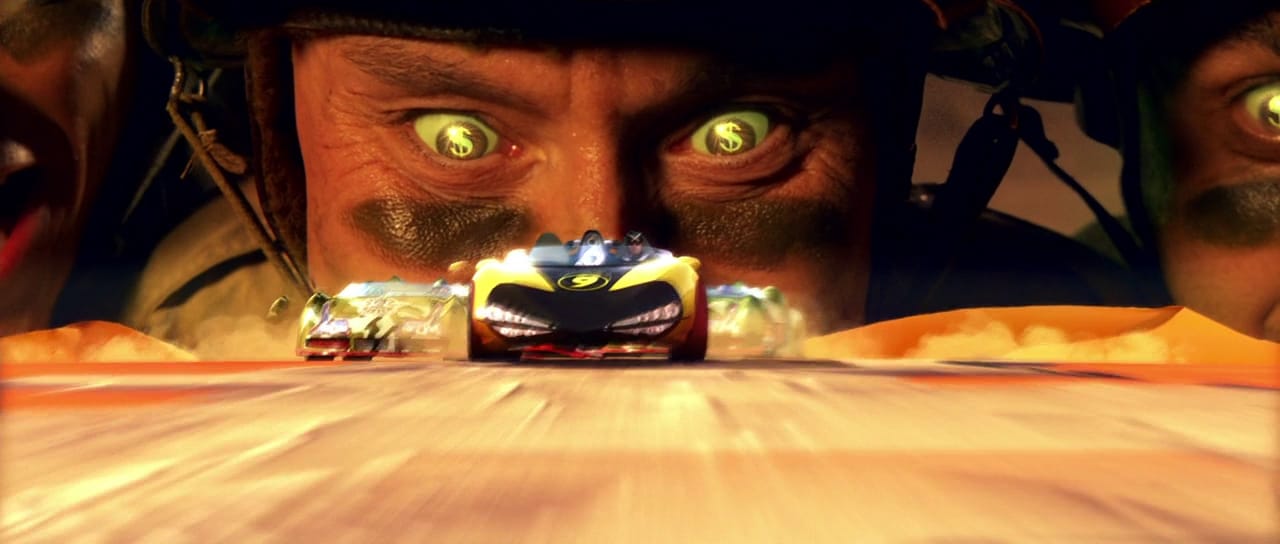 An image from Speed Racer where a menacing guy with dollar signs in his eyes overlooks the race course like a hungry hungry hippo