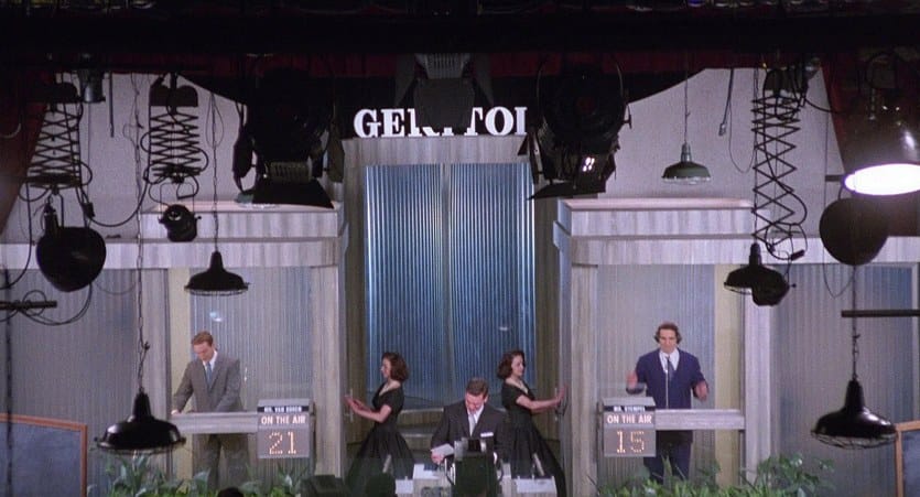 Ralph Fiennes, John Turturro, Christopher McDonald, and two assistants on the set of Twenty-One within the movie Quiz Show