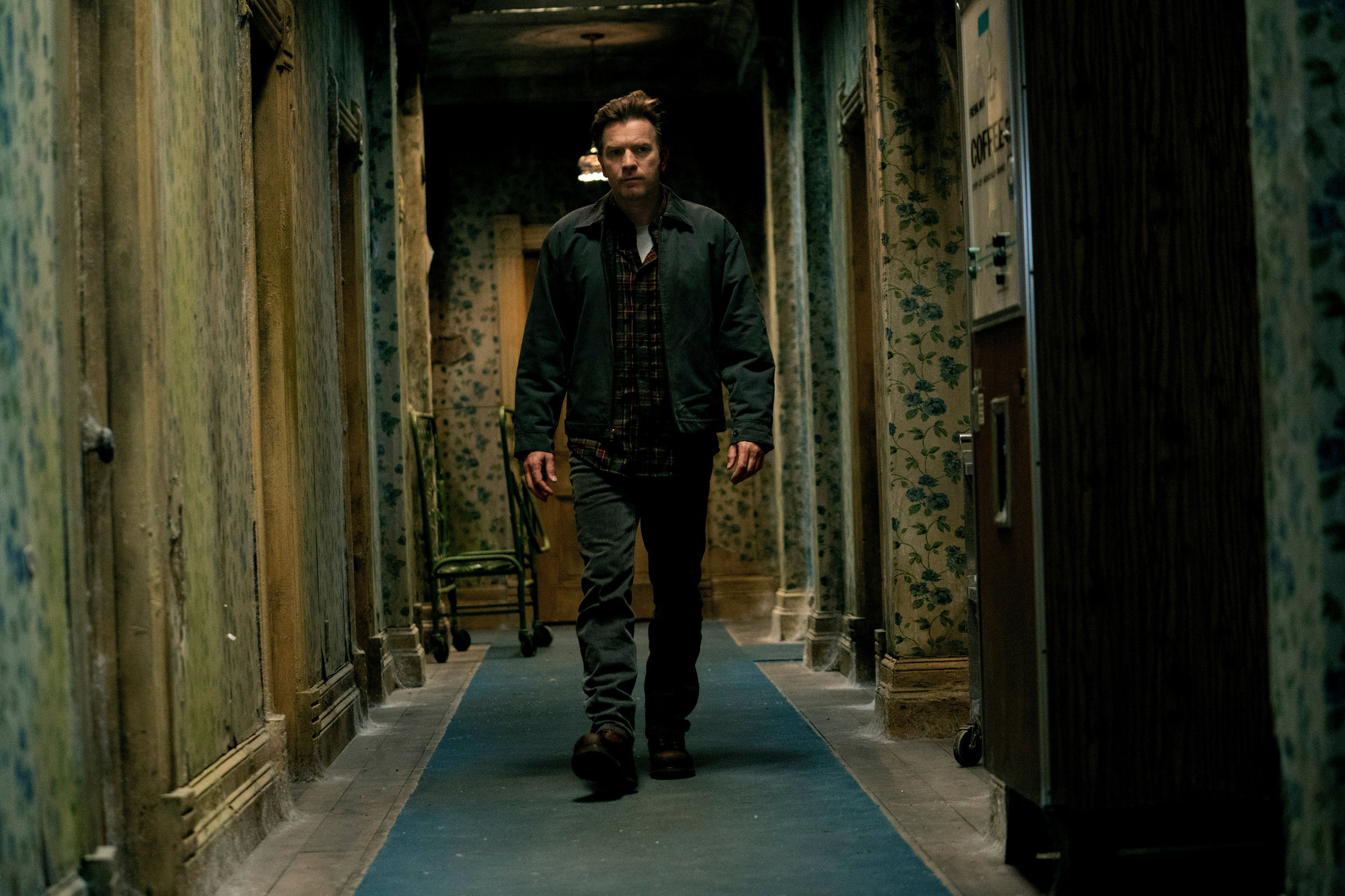 Ewan McGregor walks down a poorly maintained hallway in Doctor Sleep