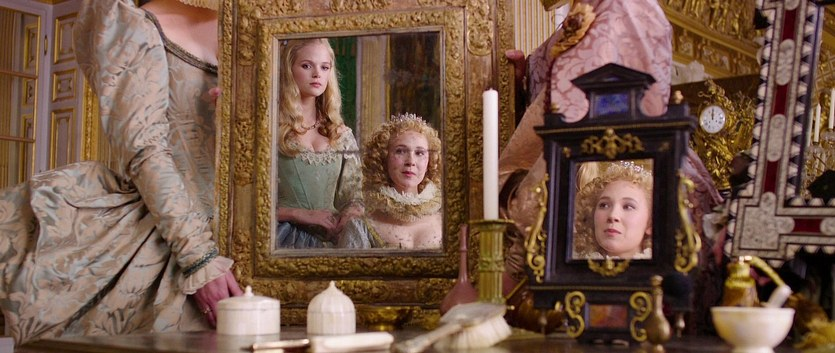 A fancily dressed woman looks at herself in an array of mirrors in The Three Musketeers