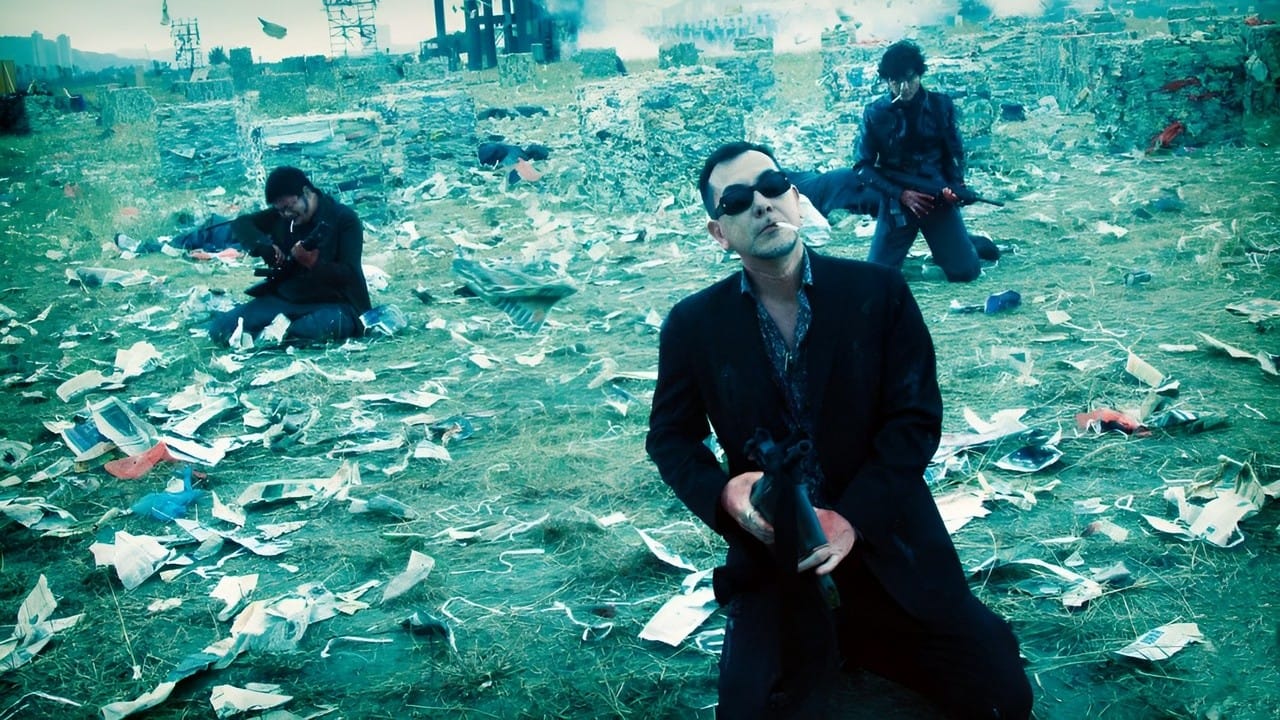 The hit men in Vengeance kneel with their guns with scattered paper and bodies around them