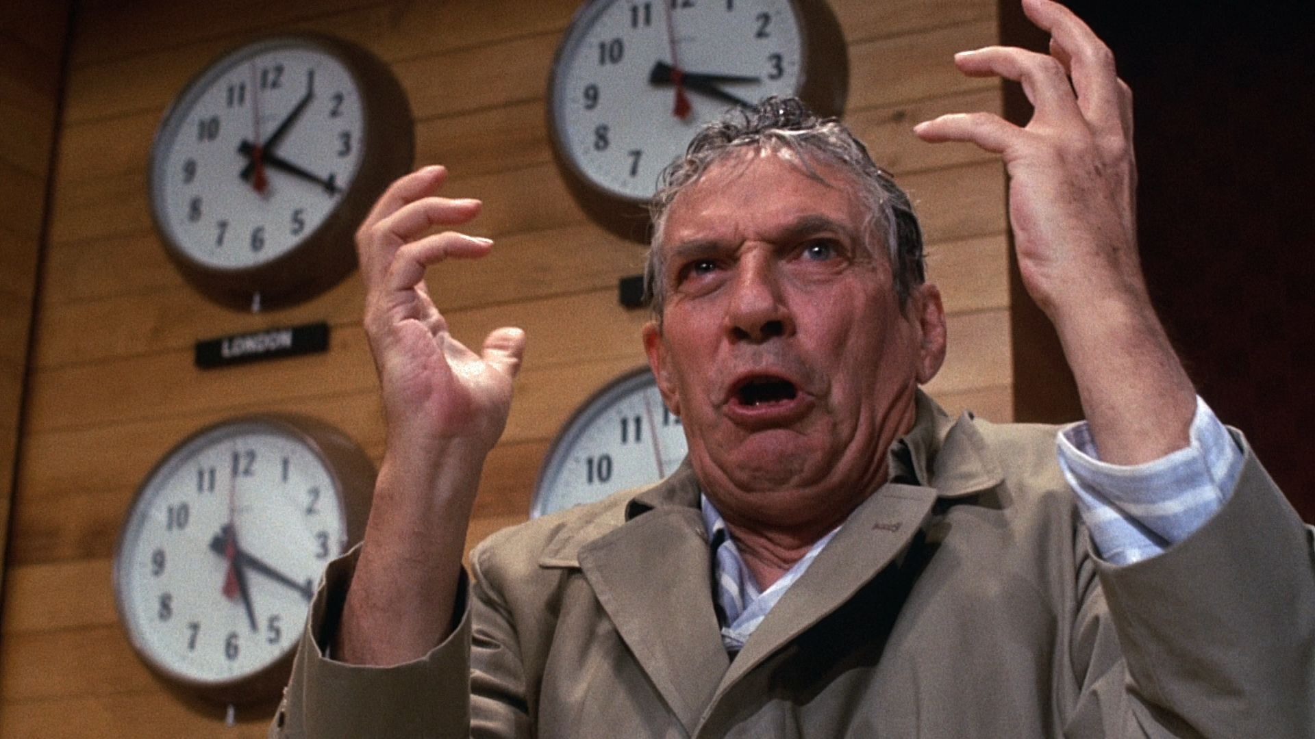Peter Finch as Howard Beale, delivering a monologue in front of a bunch of clocks in Network