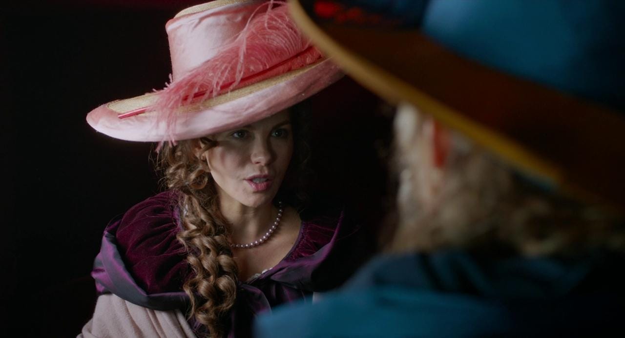 Kate Beckinsale wearing a bright pink hat in Love & Friendship
