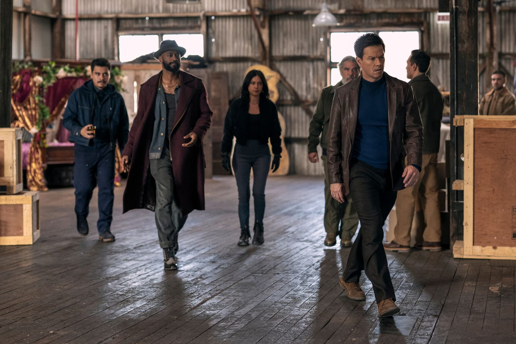 In Play Dirty, Mark Wahlberg, Lakeith Stanfield, Rosa Salazar, and the rest of the crew walk in a warehouse