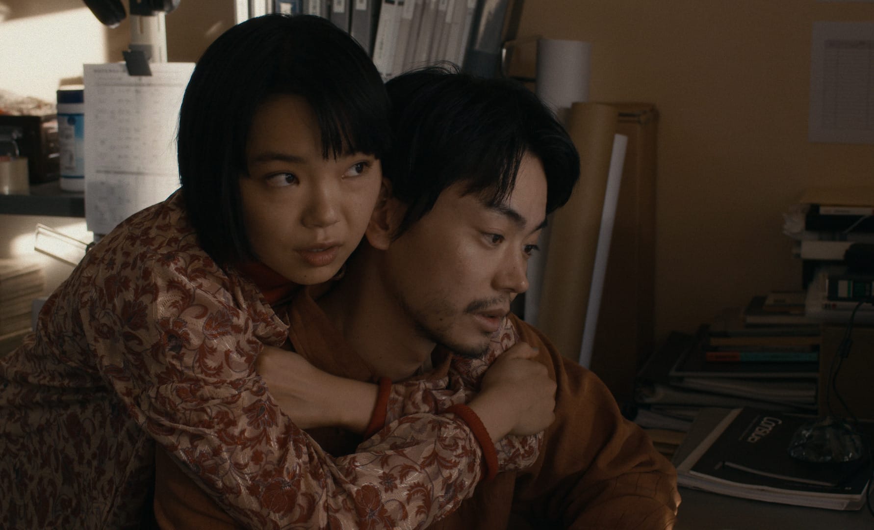 In Cloud, the main character is embraced by his girlfriend while he sits at his desk