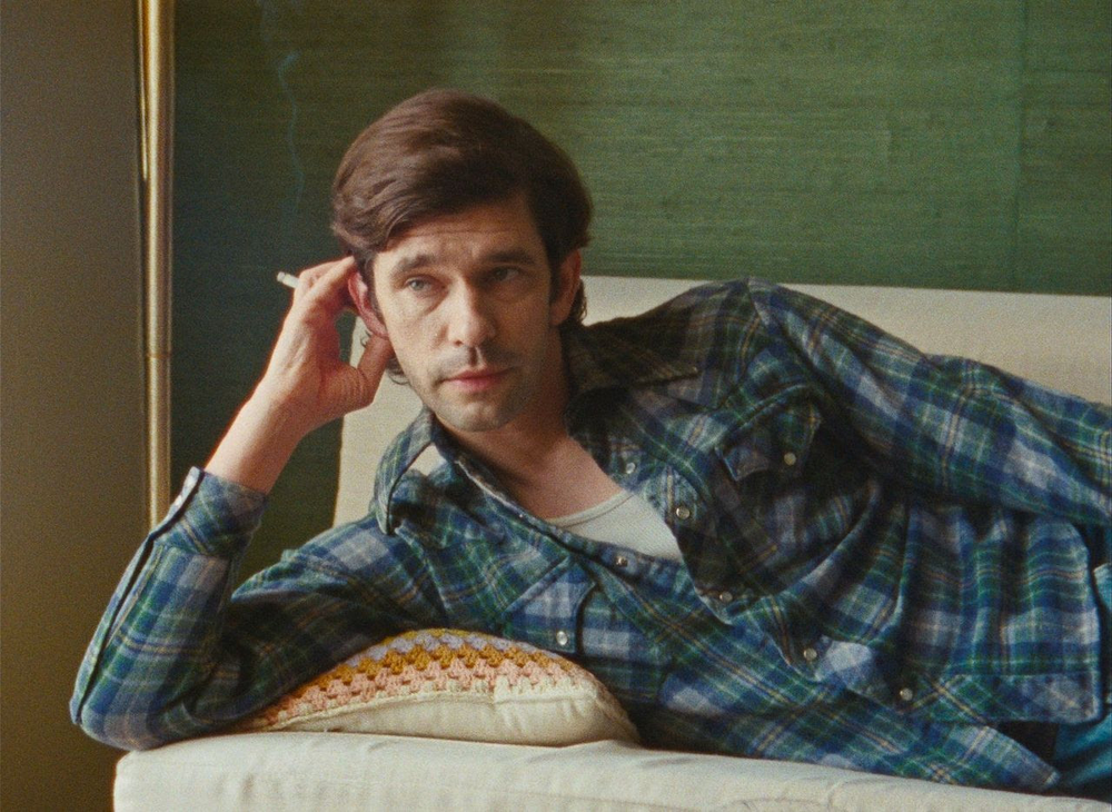 Ben Whishaw lies on a couch, holding a cigarette, in Peter Hujar's Day