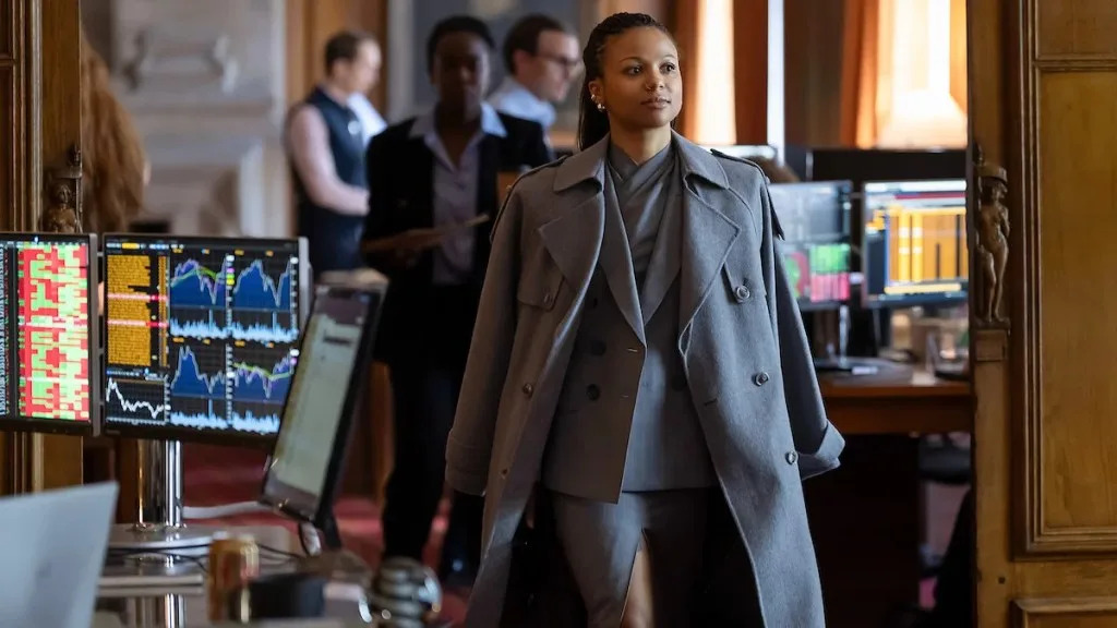 In Industry season 4, Myha'la walks confidently through an office in a large grey coat