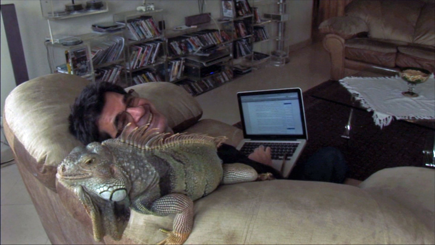 Jafar Panahi chilling with his family's pet iguana while on the computer in This Is Not a Film