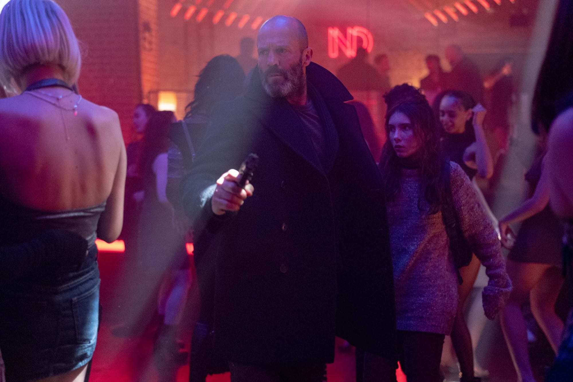 In Shelter, Jason Statham (holding a pistol) protects Bodhi Rae Breathnach in a nightclub
