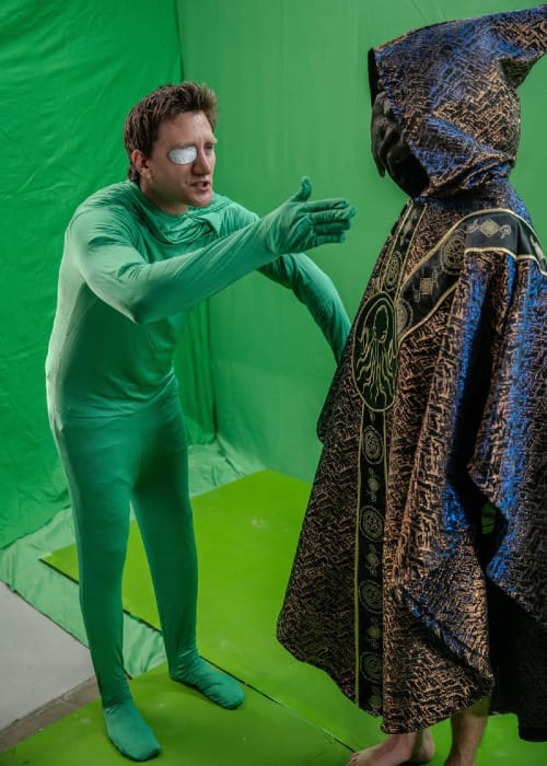 Jason Trost, wearing a green screen suit, instructs a Cthulhu-style wizard in front of a green screen