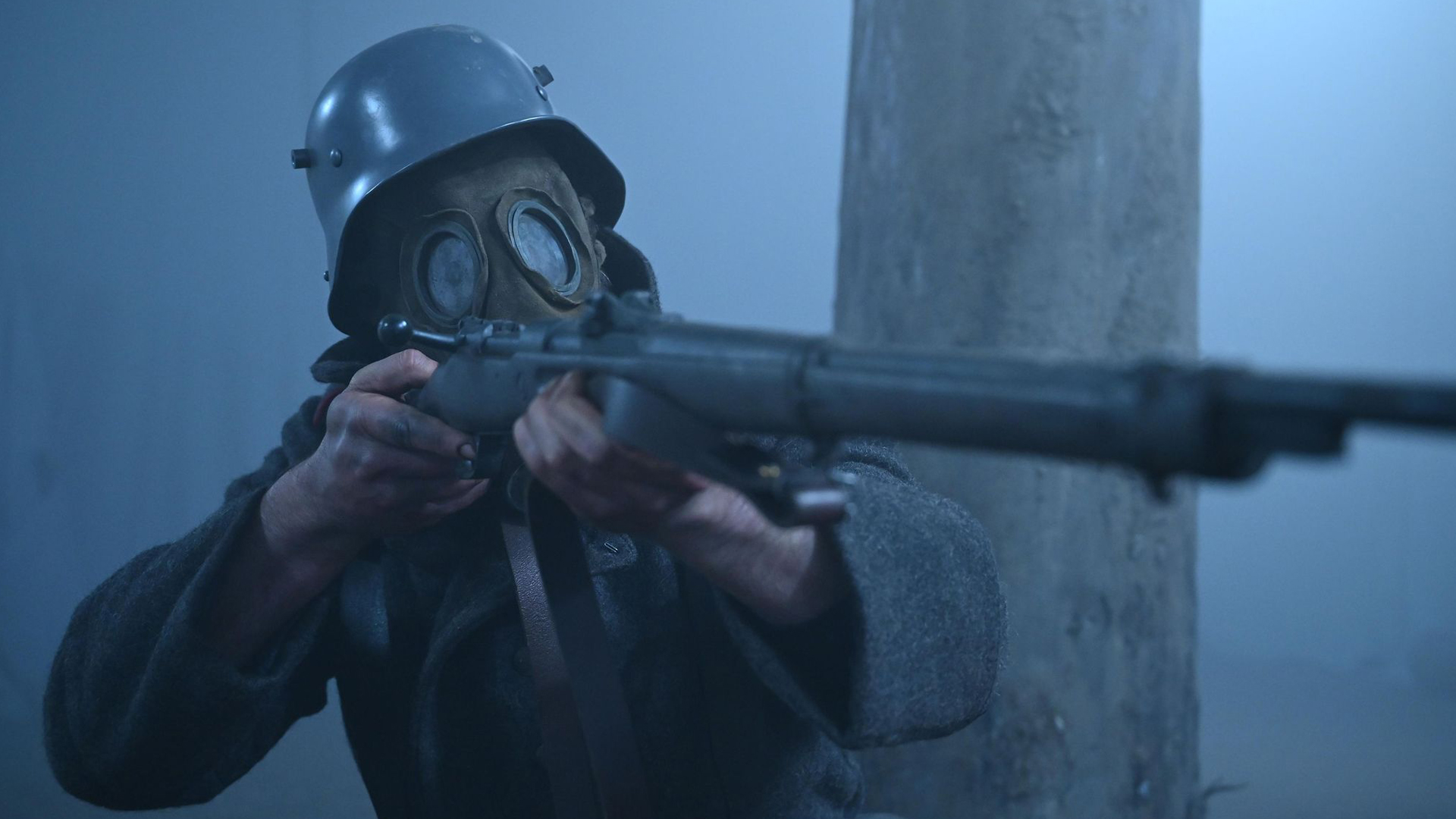 A World War I soldier wears a gas mask and points a rile in Landship