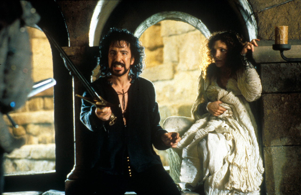 Alan Rickman as the Sheriff of Nottingham, holding out a sword with Maid Marian hostage