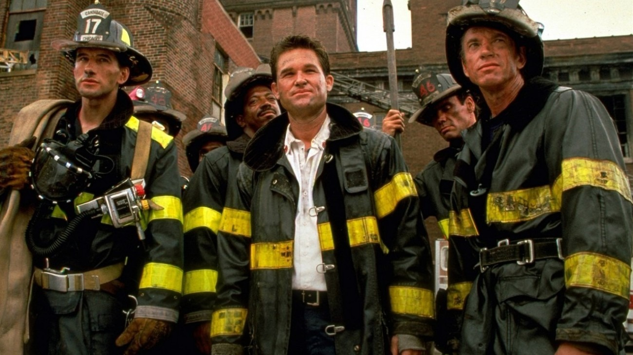 Backdraft's Engine 17 firefighting team, led by Kurt Russell, William Baldwin, and Scott Glenn, all covered in soot