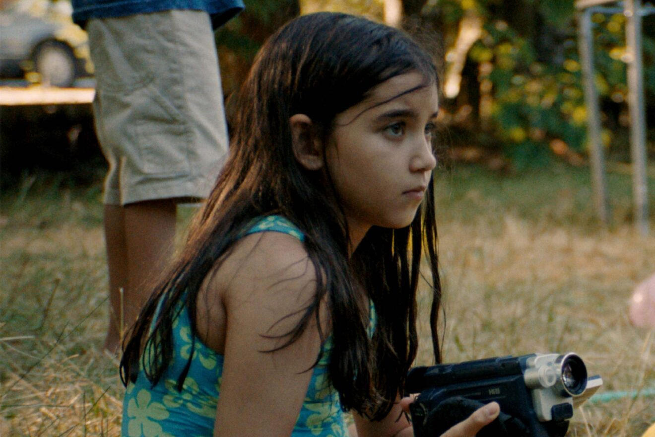 A young girl holds a camcorder in Blue Heron