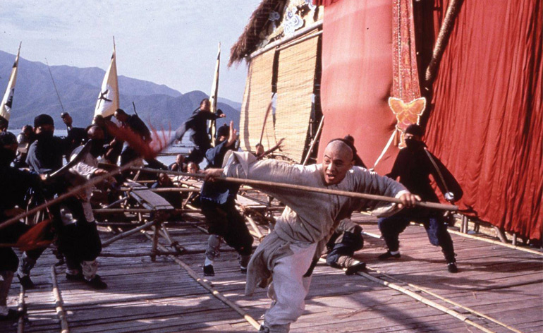 Jet Li fights off a bunch of enemies with a long weapon in Once Upon a Time in China