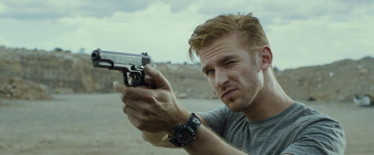 Dan Stevens aims a pistol in The Guest