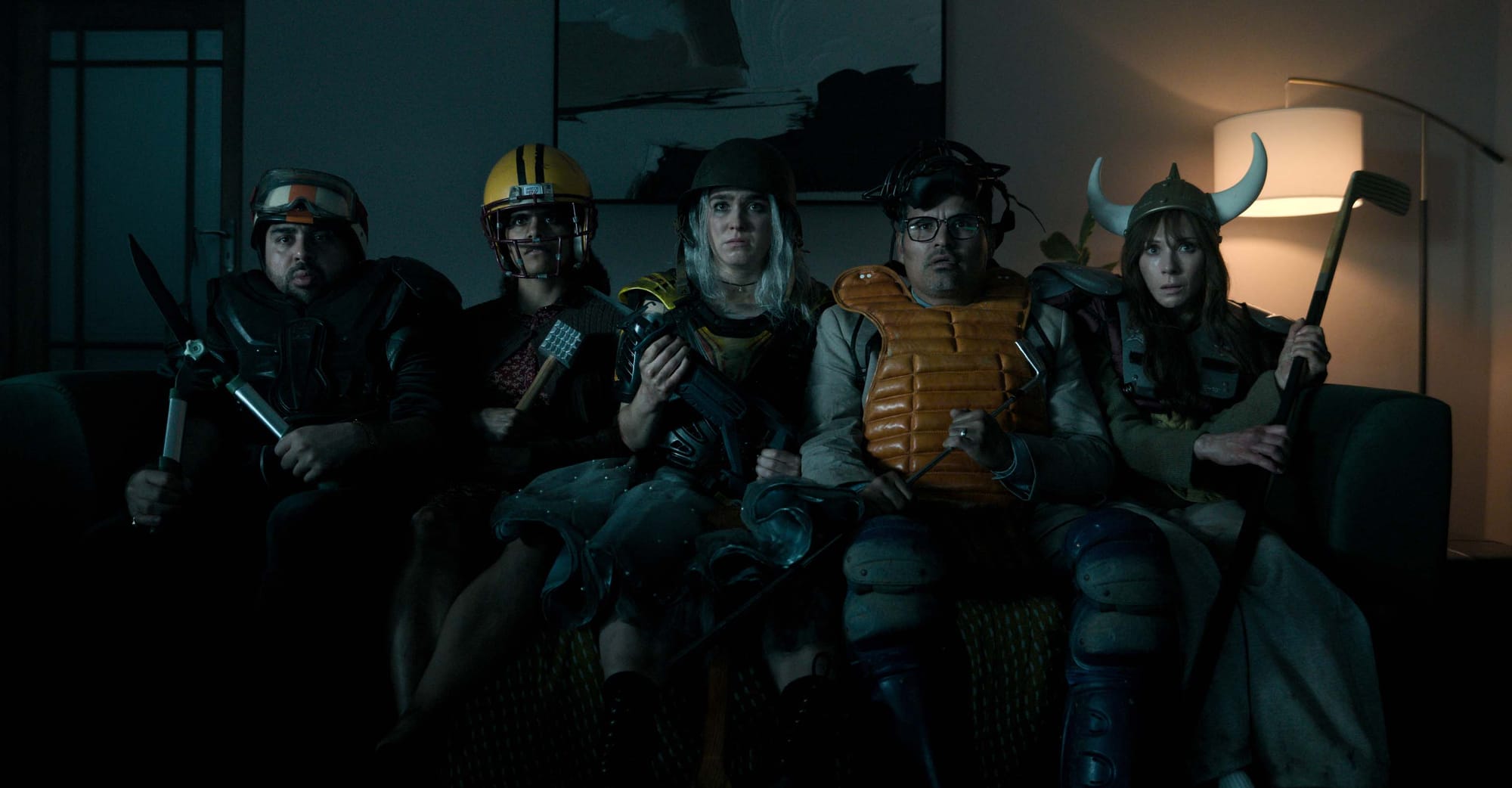 The squad in Good Luck, Have Fun, Don't Die wear sports equipment and sit on a coach as they prepare for battle